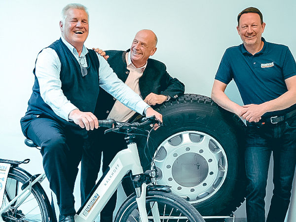 Seniorchef Michael Nabholz zusammen mit Heinrich Köppl (links) und Florian Rödig (rechts) als dessen Nachfolger in Sachen Vertriebsleitung Nutzfahrzeugreifen im Unternehmen mit dem E-Bike, das die gesamte Nabholz-Belegschaft sowie die Top Service KG und Servicequadrat GmbH dem (Un-)Ruheständler geschenkt haben (Bild: Heinrich Nabholz Autoreifen GmbH)