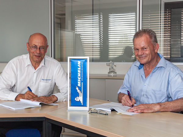 Michelin-Werkdirektor Cyrille Beau (links) und Morten Stefan Lanzenstiel, Geschäftsführer der Solar-Energiedach GmbH PV, unterzeichnen den Vertrag über die Installation zusätzlicher Solarmodule am Michelin-Standort Bad Kreuznach (Bild: Michelin/Ulrike Dalheimer)