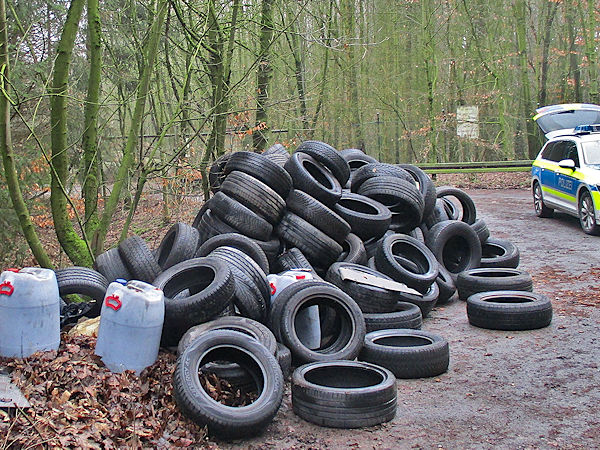 Bisher unbekannte Täter haben bei ihrer Umweltstraftat nicht nur Altreifen, sondern zudem noch etwa 400 Liter Altöl in vier Kunststofffässer wild in der Landschaft entsorgt (Bild: Polizei Bad Münder)