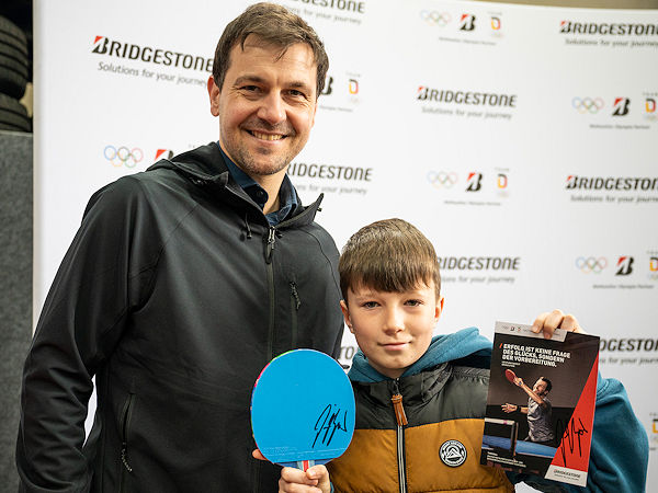 Tischtennisass Timo Boll (links) ließ es sich nicht nehmen, den vier Siegern der Bridgestone-Aktion die gute Nachricht persönlich zu überbringen, und stand dazu bei Reifen Stiebling nicht nur für Selfies und Autogramme zur Verfügung, sondern griff in der zum Trainingslager umfunktionierten Montagehalle des Unternehmens auch selbst zum Schläger (Bild: Reifen Stiebling/Arne Pöhnert)