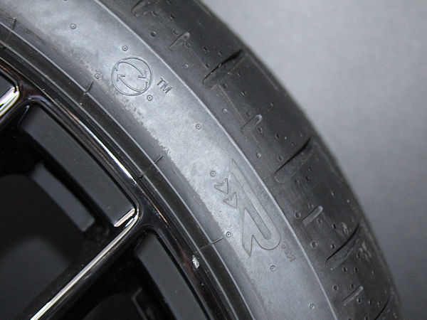 Gleich neben dem aus einem Kreis mit zwei Pfeilen bestehenden Logo, das zukünftig neue Pirelli-Reifen aus mindestens 50 Prozent biobasierten und recycelten Materialien zieren wird, gibt es beim „P Zero E“ noch eine weitere bis dato so noch nicht gesehene Kennzeichnung auf der Seitenwand: ein R mit zwei kleinen Pfeilen darunter (Bild: NRZ/Christian Marx)