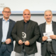 Die Preisverleihung fand im Rahmen des Zukunftskongresses Nutzfahrzeuge statt, der von Dekra und dem ETM-Verlag veranstaltet wird (von links): Oliver Trost vom ETM-Verlag mit Wolfgang Schmid, Head of Central Region bei Webfleet, und dem Vorsitzenden der sechsköpfigen Jury Prof. Dr. Heinz-Leo Dudek von der Dualen Hochschule Baden-Württemberg Ravensburg (Bild: Thomas Küppers)