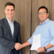 Julien Ropraz (links) – Sales Manager Retread DACH-Region (Deutschland, Österreich, Schweiz) & Nordic Countries bei Michelin – und Erwin Schwab, Geschäftsführer der Pneuhage Reifenerneuerungstechnik GmbH, besiegeln die Erneuerung ihrer Partnerschaft in Sachen Recamic-Kaltrunderneuerung (Bild: Michelin)